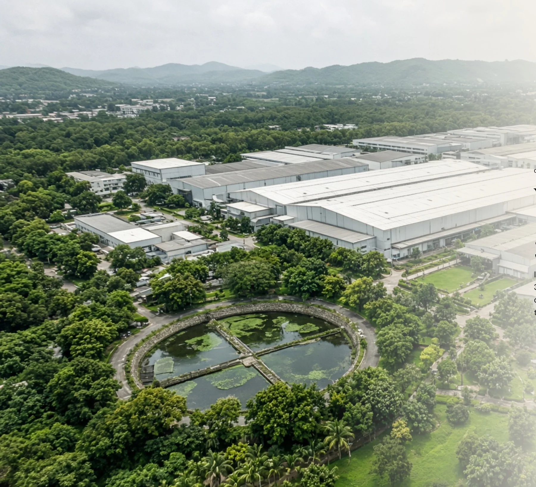 Aerial view of a large manufacturing campus surrounded by greenery